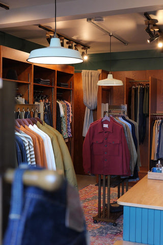 clothes hanging on rails inside auteur store
